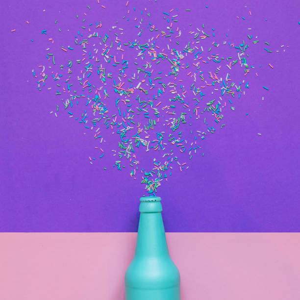 Blue champagne bottle with confetti glittering splashes. Blue champagne bottle with confetti glittering splashes. minimal holiday drink. flat lay spilling photos stock pictures, royalty-free photos & images