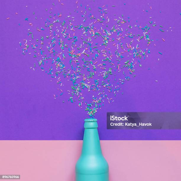 Blue Champagne Bottle With Confetti Glittering Splashes Stock Photo - Download Image Now