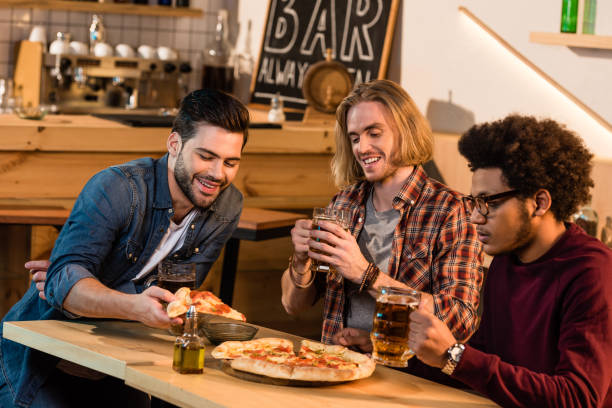 istock friends with pizza and beer in bar 896769130