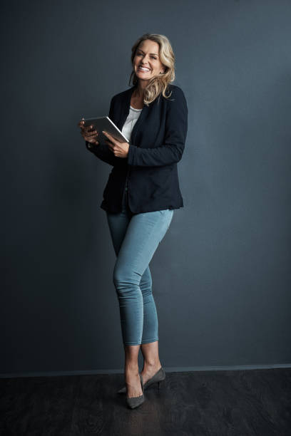 Studio portrait of a mature businesswoman using a digital tablet against a grey background