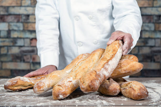 istock baker with traditional bread french baguettes 896777792