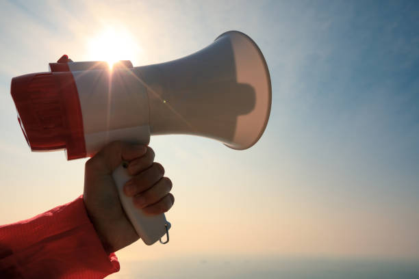istock shouting with loudspeaker on windy sunrise coast cliff edge 896788336