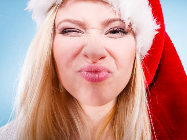 istock Woman wearing Santa Claus hat making faces 896791662