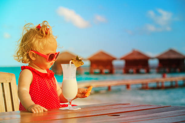 istock cute little girl drinking cocktail on tropical beach 896805892