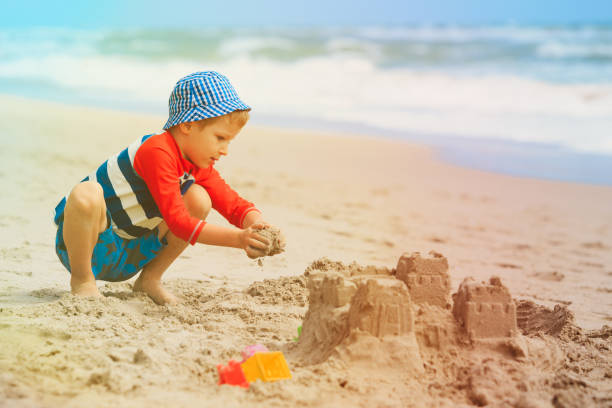 istock little boy play with sand on beach 896808872