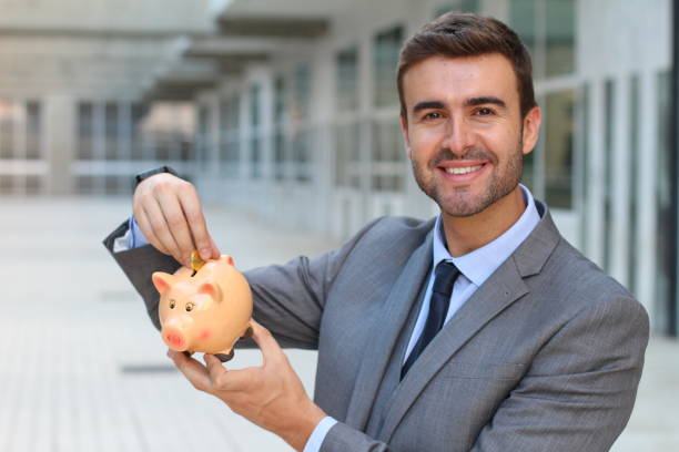 istock Businessman using a piggybank to save money 896809036
