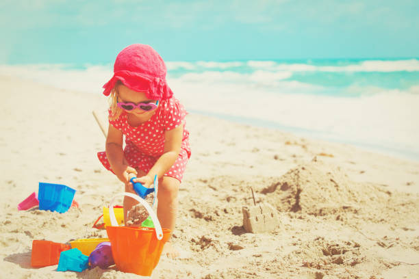 istock cute little girl play with sand on beach 896809122