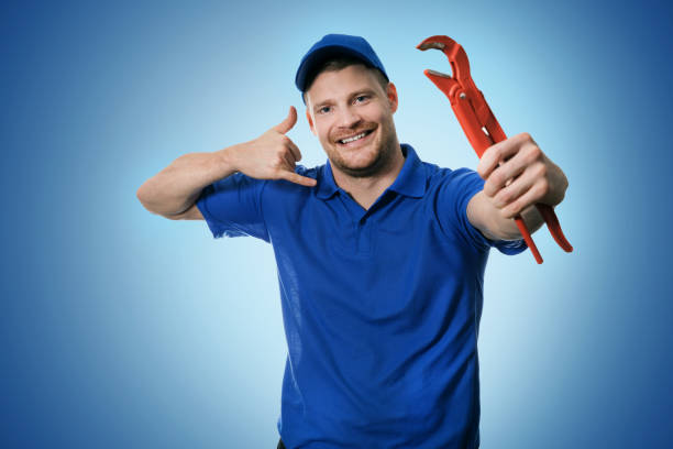 istock plumbing services - plumber with wrench showing phone call gesture on blue background 896809328