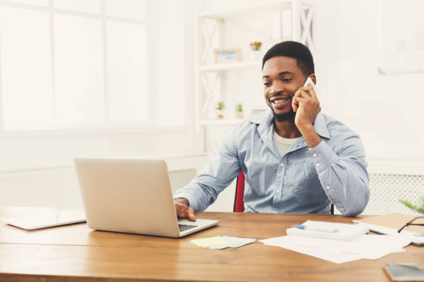 istock Young black businessman talking on mobile phone 896819582