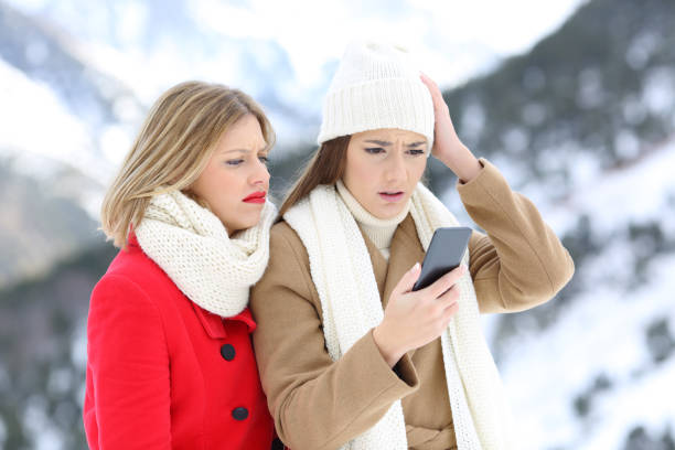 istock Confused friends with a smart phone in winter 896822376