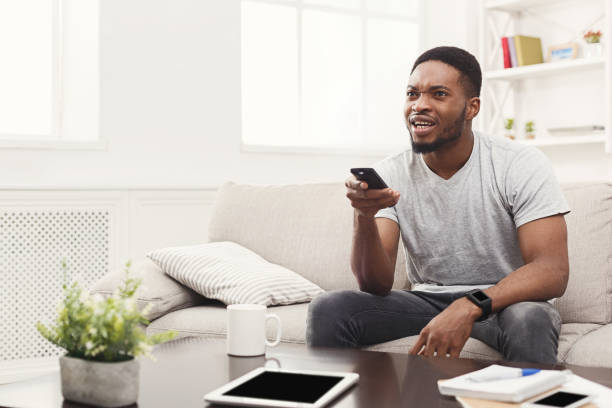 istock Worried young man wathing tv at home 896822980
