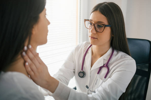 Female doctor checking the throat of a patient Female doctor palpating lymph nodes of a patient. Medical exam. lymph node photos stock pictures, royalty-free photos & images