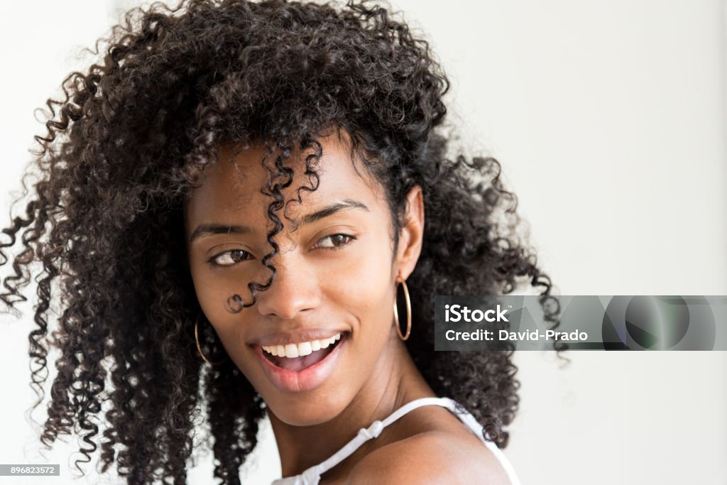 Portrait of a beautiful young black woman looking into camera "n Curly Hair Stock Photo