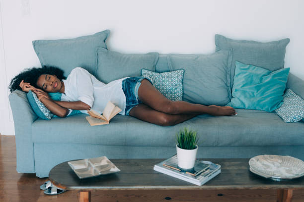 ソファで寝ている黒い若い美人 - african descent women american culture human hair ストックフォトと画像