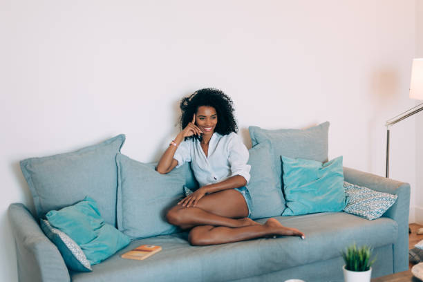istock Beautiful black young woman seating in the sofa 896825630