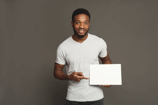 화이트 빈 보드를 들고 젊은 아프리카계 미국인 남자의 그림 - index card holding paper men 뉴스 사진 이미지