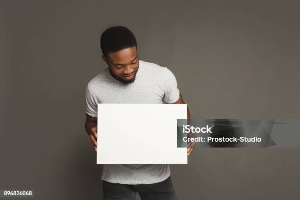 Picture Of Young Africanamerican Man Holding White Blank Board Stock Photo - Download Image Now