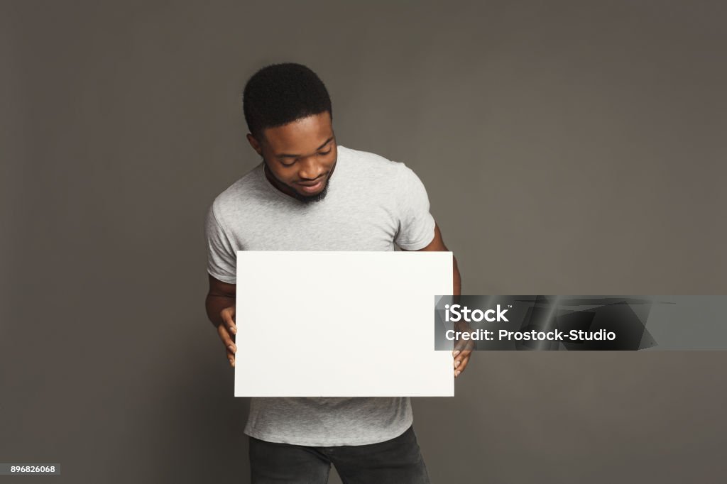 Foto de jovem afro-americano, segurando a placa branca em branco - Foto de stock de Segurar royalty-free