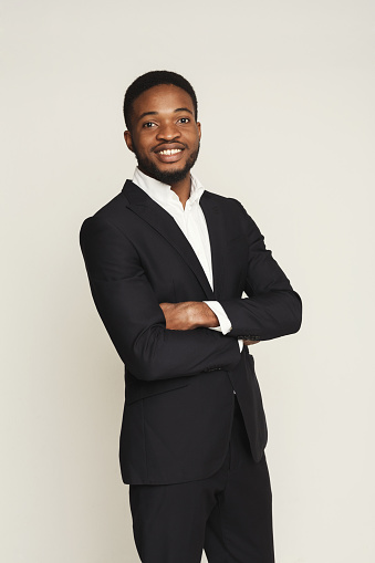 Happy smiling young black man portrait in formal wear at white studio background, crop
