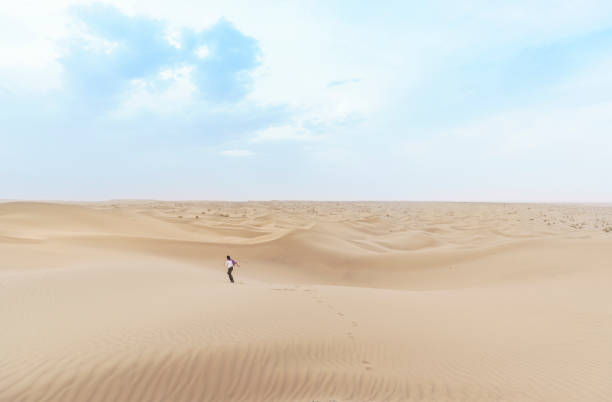 istock Small human amidst beautiful sand dunes on stunning massive Mesr desert in central Iran 896831354