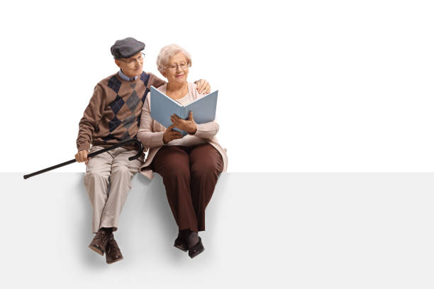 istock Elderly couple sitting on a panel and reading a book 896832322