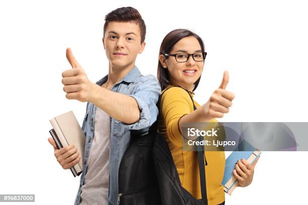 Foto de Estudantes Adolescentes Com Mochilas E Livros Tornando O Polegar Para Cima Gestos e mais fotos de stock de Estudante