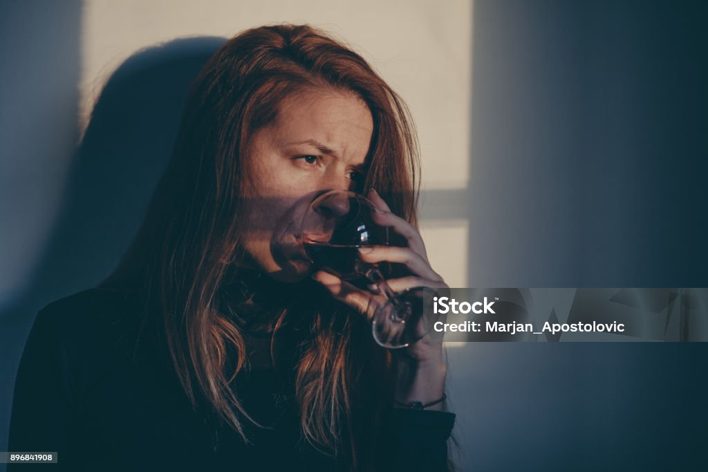 Drunk woman drinking wine alone and depressed Alcohol - Drink Stock Photo