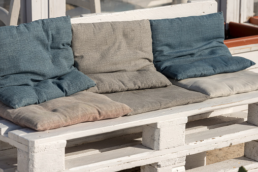 Sofa made of white wooden pallet and cushions of cloth. Outdoor setting