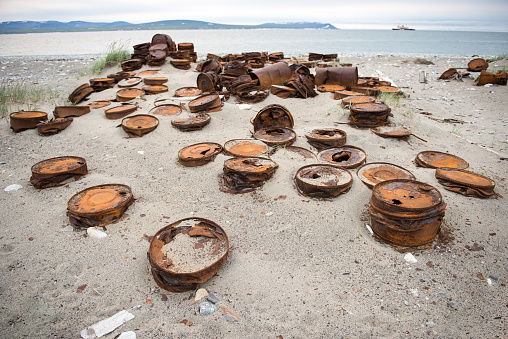 Rusted barrels on the shore, Chukotka, Russia