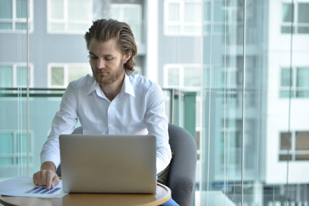 istock Stressed western businessman using a laptop in living room 896849198