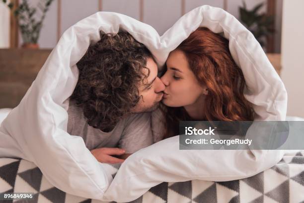 Coppia A Casa - Fotografie stock e altre immagini di Baciare - Baciare, Relazione di coppia, Letto