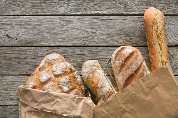 istock Bread bakery background. Brown and white wheat grain loaves composition on rustic wood 896877414