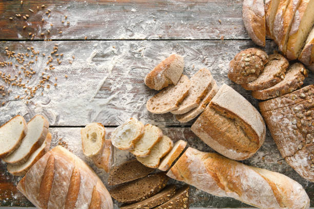 istock Bread bakery background. Brown and white wheat grain loaves composition on rustic wood 896877588