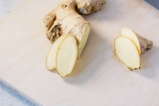 istock Slices of ginger root on wooden board. 896880926