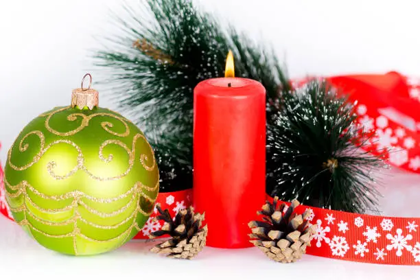 red burning candle and xmas tree decorations, christmas composition isolated on white
