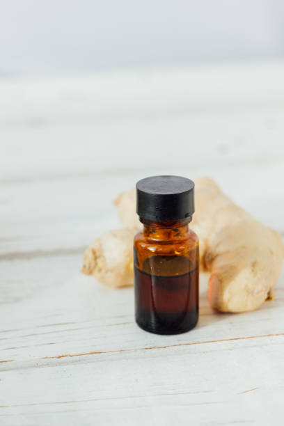 istock Ginger essential oil in glass bottle with ginger root behind. 896885504