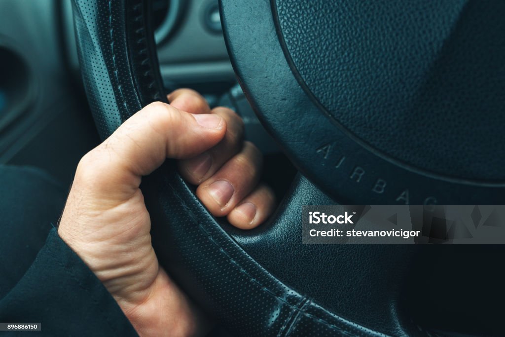 Car steering wheel with airbag sign Male hand holding car steering wheel with airbag sign Gripping Stock Photo