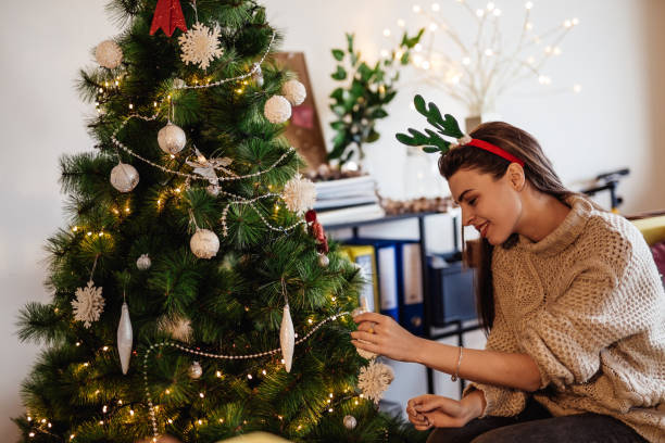 istock Young woman decorating her Christmas tree 896886610