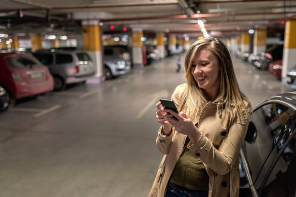 istock Businesswoman using mobile phone in parking lot 896886754