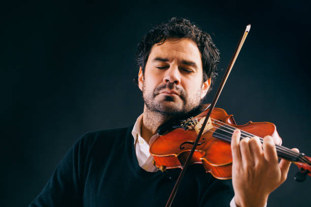 istock Violinist playing in black background. 896891970