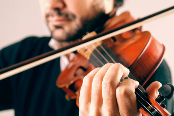 istock Close up Violinist playing with a stave background 896892120