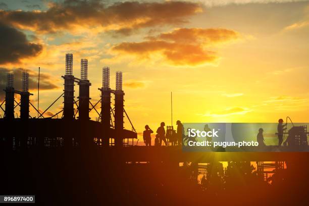 Construction Worker Working On A Construction Site Stock Photo - Download Image Now - Construction Site, Sunset, Construction Industry