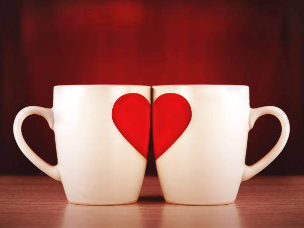istock Two mugs with the image of a heart half 896902402