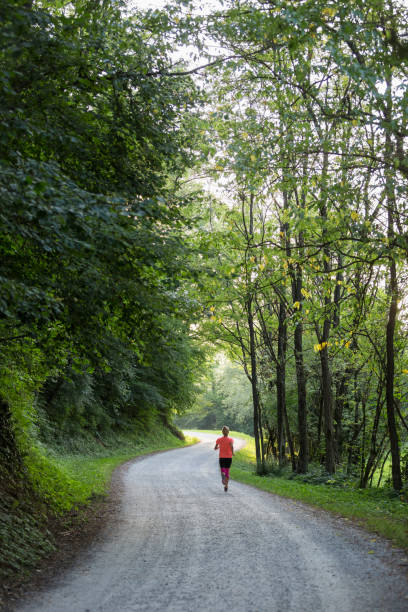 istock Female athlete running through the woods 896906676