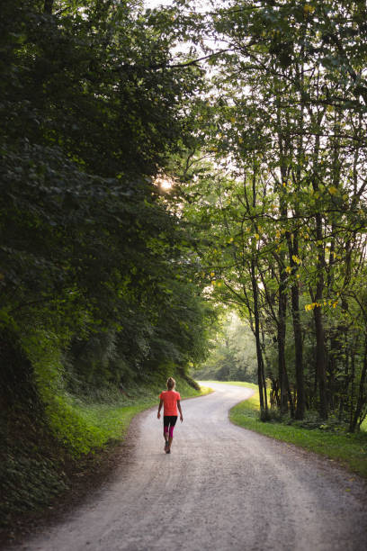 istock Young female running through the woods 896906894