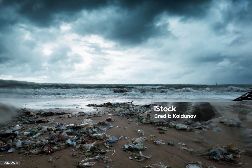 Immondizia sulla spiaggia, inquinamento ambientale a Bali Indonesia. La tempesta sta arrivando. E gocce d'acqua sono sull'obiettivo della fotocamera - Foto stock royalty-free di Mare