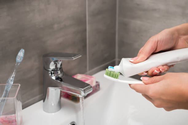 istock girl applying toothpaste on toothbrush 896929622