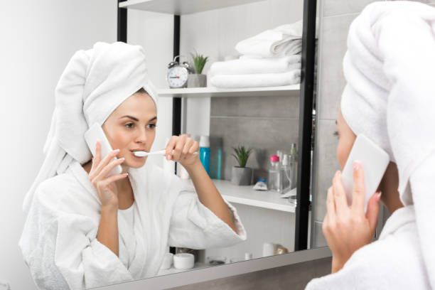istock Woman talking by smartphone and brushing teeth 896930176