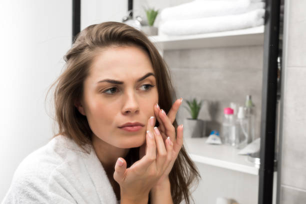 istock Woman checking face skin 896930370