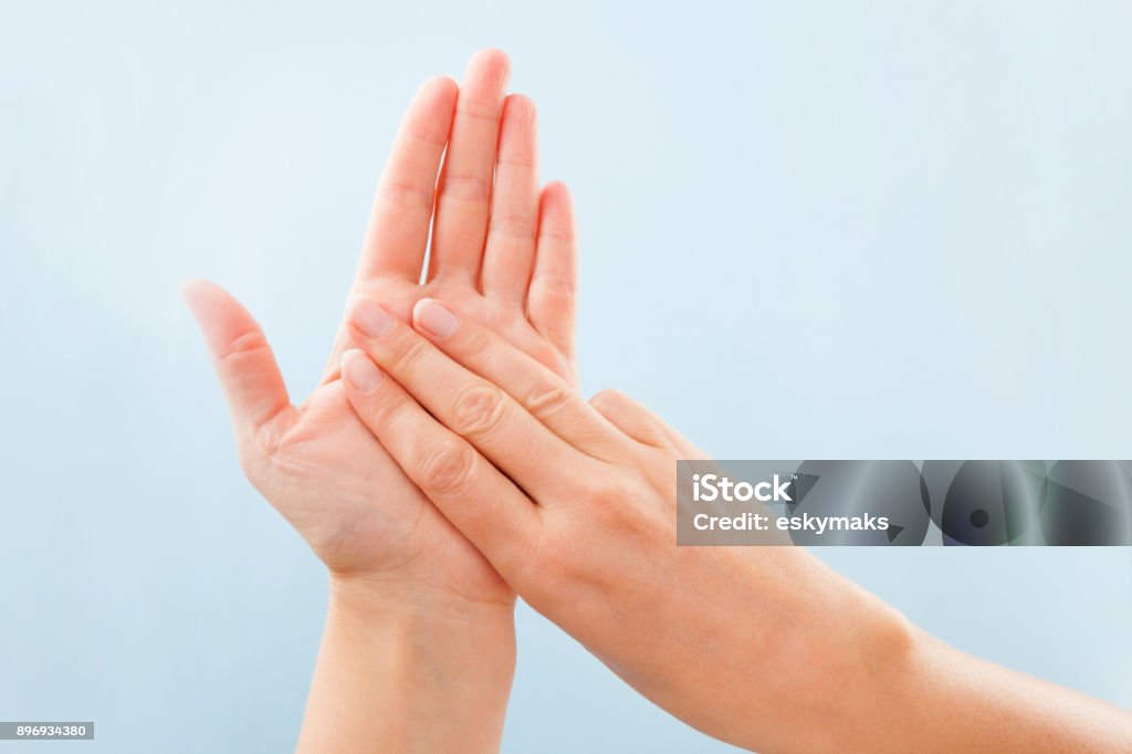 BSL Fingerspelling alphabet. Fingerspelling alphabet. Female hands isolated on blue background showing deaf mute BSL alphabet letter M. Sign Language Stock Photo